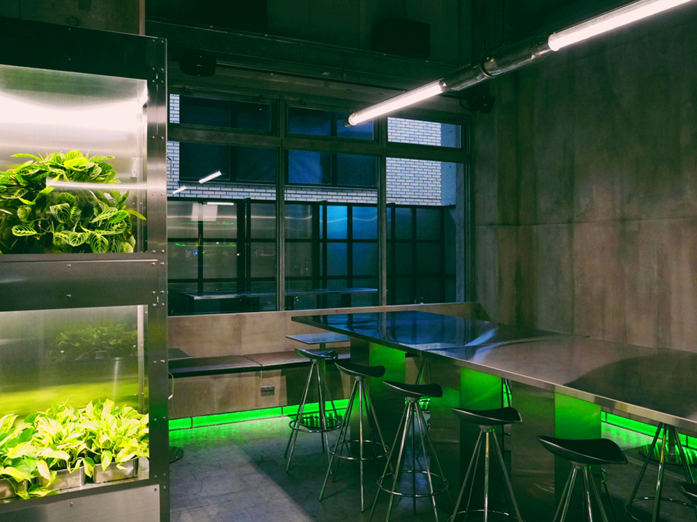 カフェエリアに配されたグリーンが、インダストリアルな空間に“生のエスプリ”を効かせている
