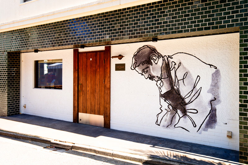 店舗外観。ハンガリー出身の画家であり彫刻家であるシャーンドル・ゼレナーク氏が描いた遠山氏がお客さまを出迎える