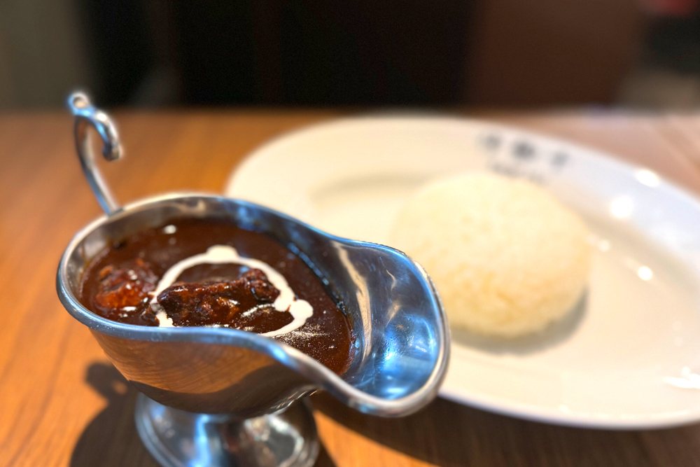 "松阪牛すじのスパイシーブラックカレー" 。松阪牛の牛すじをふんだんに使った贅沢なカレー。 香辛料が独自配合されており、スパイシーさを引き出し、八丁味噌を使うことでコクと風味が出るように工夫した。日本の"洋食" を意識して仕立てたカレーになっている