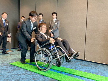 車いすを用いたサポート走行:人工芝の上で走行をサポート