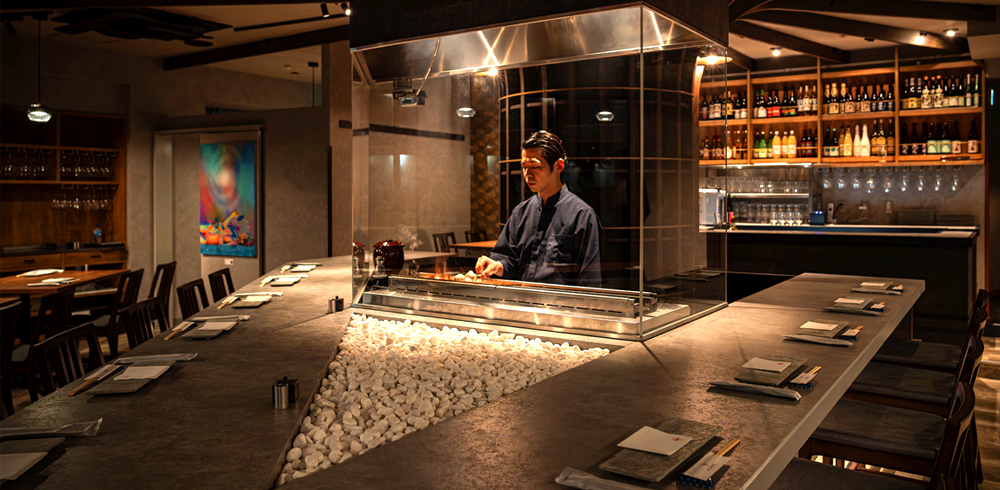 個性的なカウンター席も、同店のこだわりのひとつ。焼き場前に設えられた白石は、料理を撮影する際の“映え効果”が高い。さらに、ガラス越しに焼き場を担当する料理人とのコミュニケーションも楽しめる設計となっており、おひとりさまでも疎外感なく、ゆっくりと食事を堪能できる
