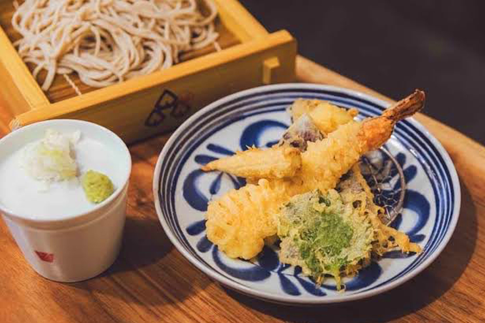 相馬庵名物の”天せいろ”。揚げたての天ぷらと、打ち立て・茹で立ての十割蕎麦を贅沢に味わえる、同ブランドの看板メニューだ。天ぷらは一品料理としても注文可能で、冷酒やバラエティ豊かなお茶割り、サワーのお供にもいい