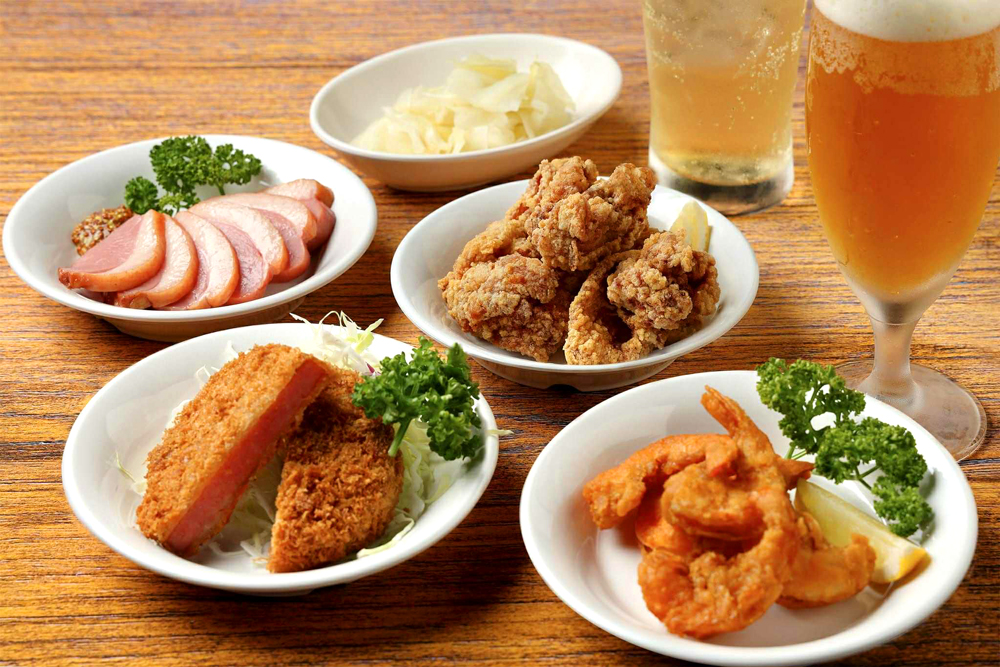今回の出店にあたり、空港側からのリクエストとして‟夜時間の活性化“が挙がった。そこで、お酒との相性を意識した小皿メニューも充実させた。「紅茶鴨のスモーク（画像左奥）」など珍しいメニューもあり、帰着後のひと息はもちろん、見送りの一献にも気軽に立ち寄れるのが嬉しい