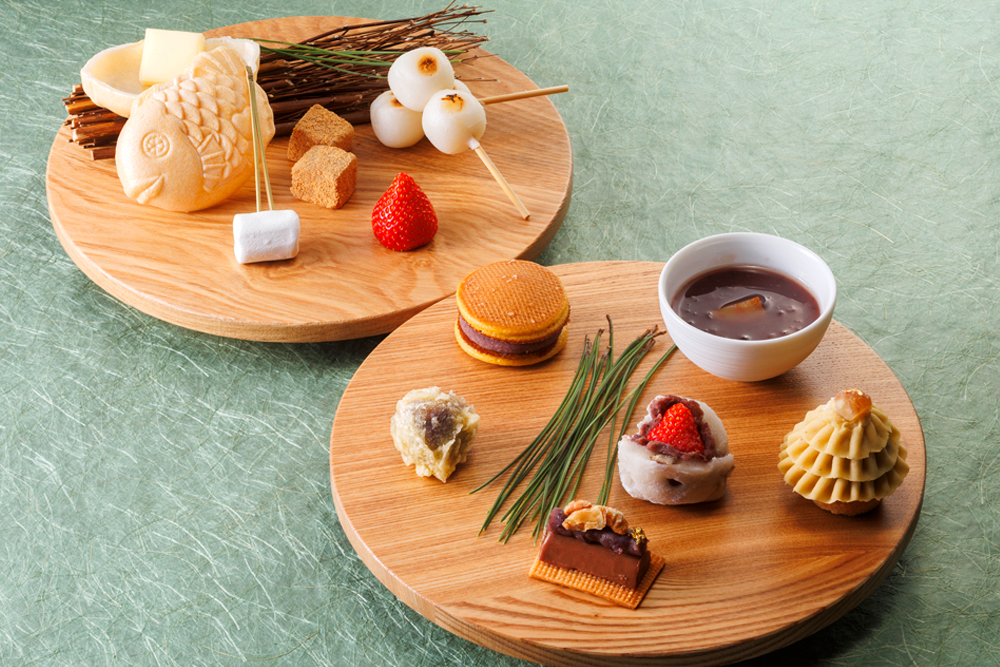 スイーツプレートは、写真後方が時計回りに、もなか、わらびもち きなこ、だんご、いちご、マシュマロ。写真手前には、塩バターどら焼き、栗のお汁粉、栗あんのモンブランタルト、フルーツ大福、ショコラ羊羹、おはぎの天婦羅が並ぶ。フルーツ大福の中身は、12月～1月がマスカット、2月～3月がいちごで提供される