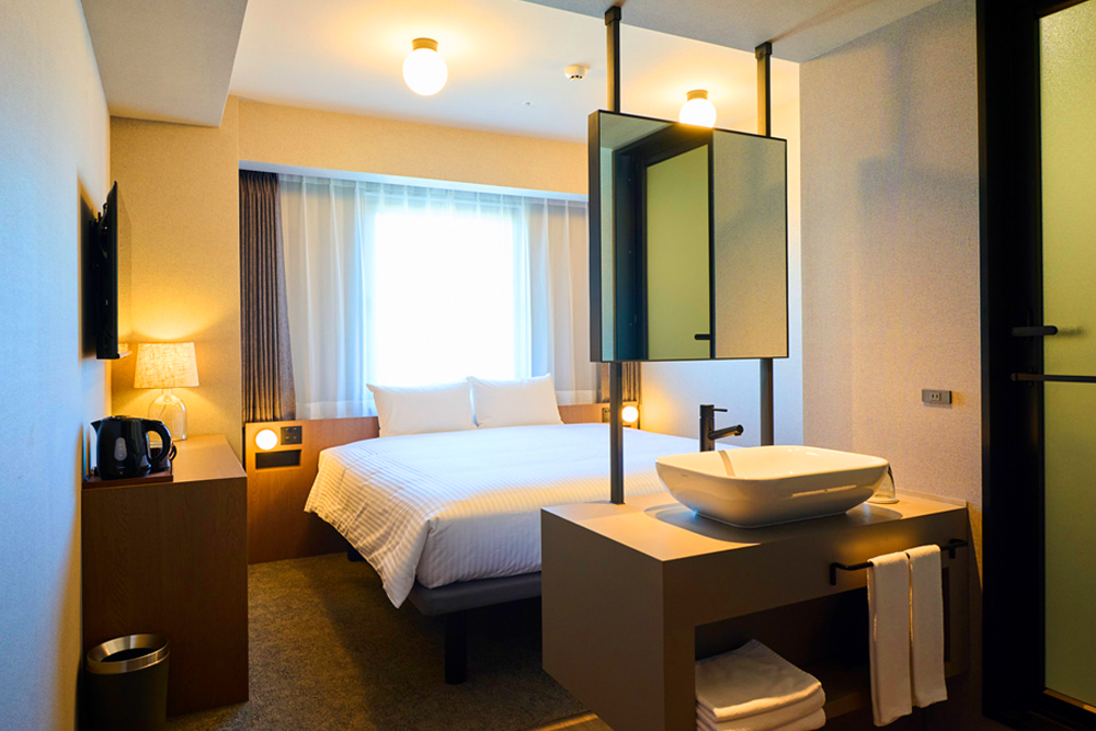スーペリアキング。客室は全室、湯船は設けずシャワールームのみとし、トイレは別に設ける形でリノベーションした。鏡をエントランスエリアとベッドの間に配置することで、オンとオフの空間を演出した。ビジネス利用やカップル、小旅行など、幅広い滞在に対応する客室としてデザインされている