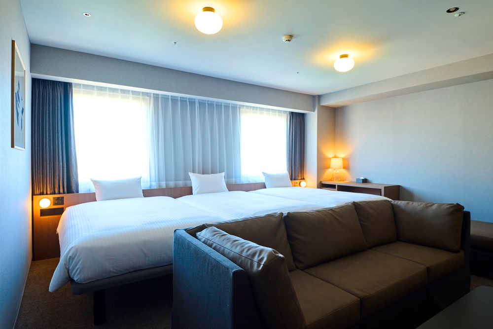 スーペリアトリプル。25㎡の広さにセミダブル3台を配し、ゆったりと過ごせるレイアウトとなっている。女子旅やグループ旅行、家族旅など、小グループでの利用に向いている。ちなみに同ホテルでは、12歳までの児童は添い寝対応ということで宿泊代は無料としている