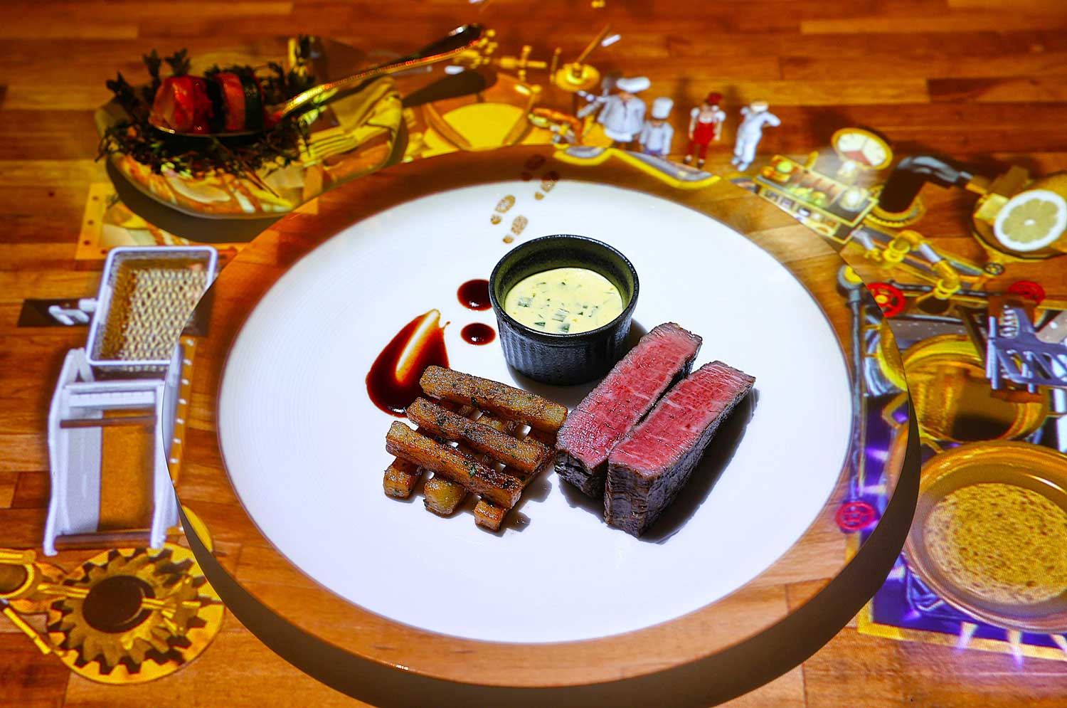 フランスのシェフ（ル・プチシェフ）による「メイン料理」は、最先端マシーンで作り上げる国産牛のステーキ、揚げたてのフレンチフライとベアルネーズソースを添えて