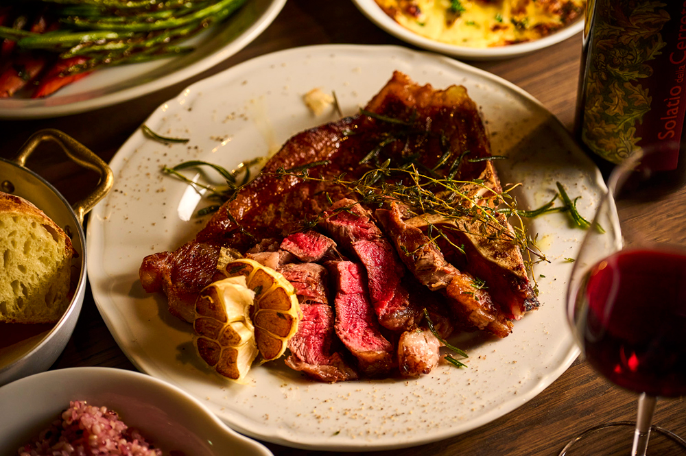 ディナータイムにはイタリアンを軸に、肉や魚のグリル、前菜、パスタ、リゾットまで幅広いメニューを展開する。日光サーモンや那須ヤシオポーク、足利マール牛に栃木野菜をふんだんに使った料理が多く並び、グループでの訪問ではシェアしながら楽しめるコースも用意されている（画像は‟LAZULI PLACE GRILL COURSE“から Tボーンステーキコース）