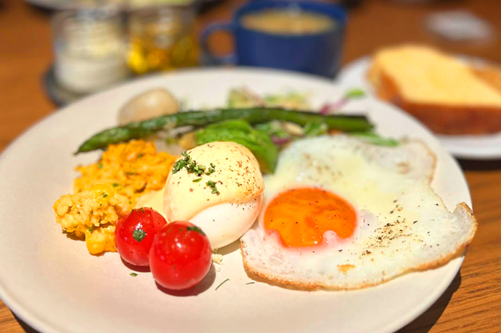 朝食は栃木県産の新鮮な野菜と、「LAZULI BAKERY」から届く焼きたてのパンが並ぶブッフェスタイル。メインには宇都宮「卵明舎」の磨宝卵を使った‟ベーコン＆スクランブルエッグ“、‟ベーコン＆サニーサイドアップ“、‟エッグベネディクト＆アボカド“が揃い、豪華な内容となっている