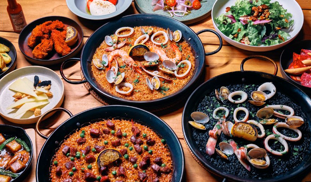 レストラングランドメニューから、‟小豆島醤油を使った黒アヒージョ“や”小豆島鮮魚のカルパッチョ“、”バニラアイスクリーム 小豆島のEXバージンオリーブオイルと黒胡椒“など。土地の恵みを活かした料理が並ぶ。ランチはパエリアを主役にしたドリンク付きのコースを用意している